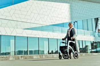 Disabled person walking with a rollator