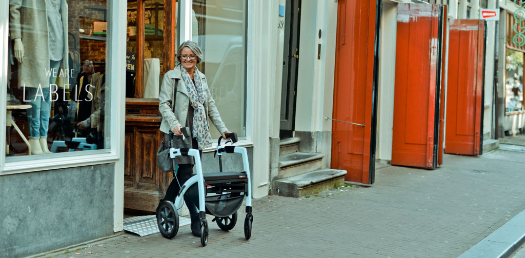 Dame, die in Amsterdam mit Rollator geht