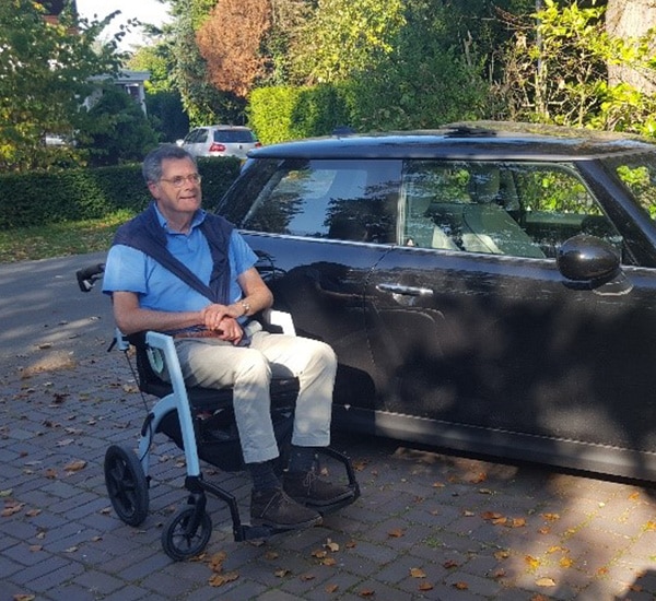 Man zit in de transportstoel terwijl hij naar buiten gaat om een museum te bezoeken