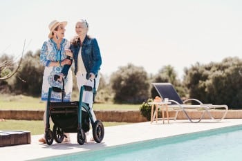 Woman walking with a Rollz Motion Performance rollator walker near a swimming pool