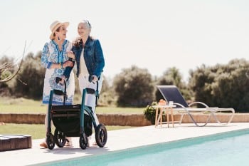 Frau geht mit einem Rollz Motion Performance Rollator in der Nähe eines Schwimmbads