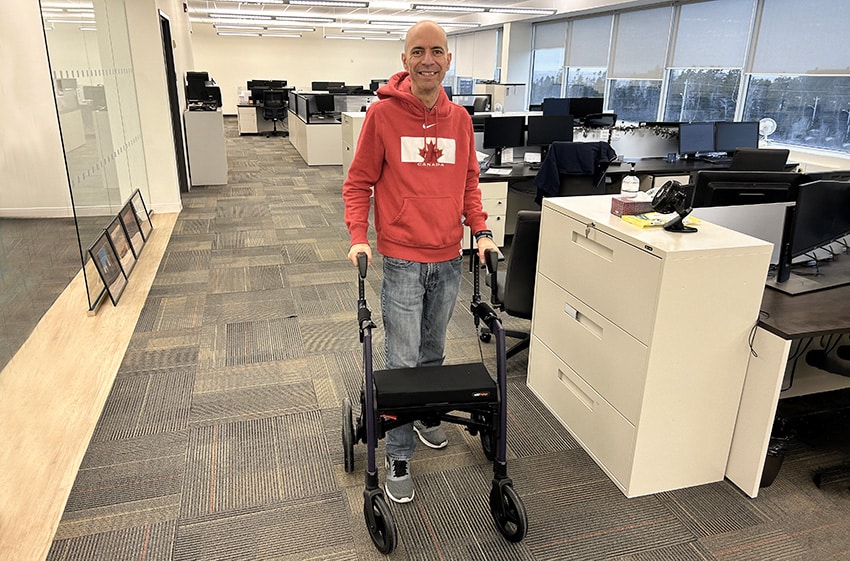 Man using a Rollz Motion rollator walker taking his disability at work