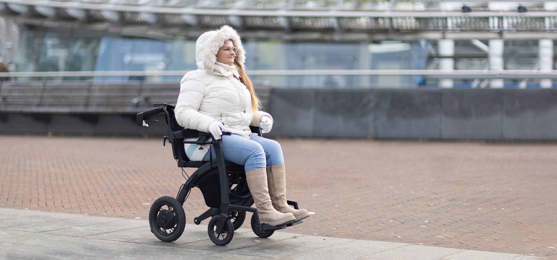 Woman driving a Rollz Motion Electric wheelchair outdoors