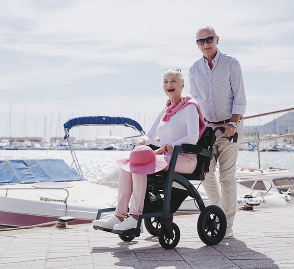 Man pushing a woman in a sustainable Rollz rollator