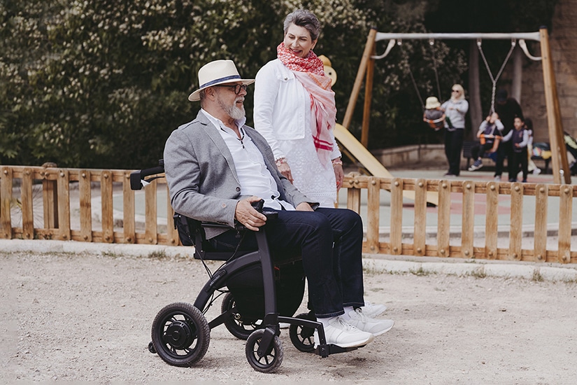 Man driving a Rollz Motion Electric wheelchair in a parc