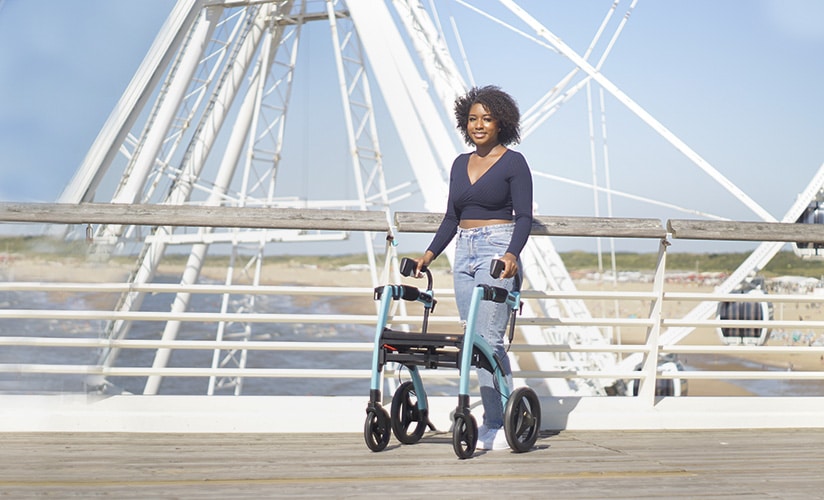 Woman walking with a Rollz Motion rollator with seat at a beach