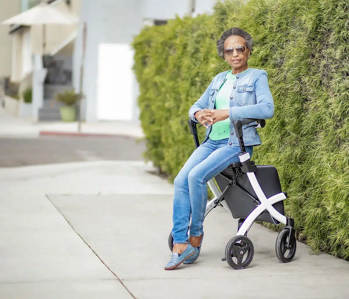 sitting on a lightweight rollator walker with shopping bag
